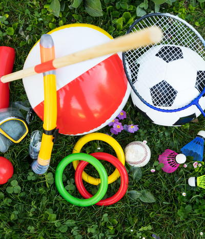 Assorted outdoor toys including a鼓, rings, and sports equipment on grass